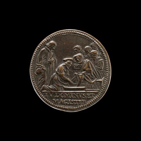 Colour photograph. Documentation of a brown, slightly worn coin, photographed against a black background. The coin features a raised, dotted pattern around its circumference, and has a low-relief illustration featuring a cluster of people centred around a seated man having his feet washed by another.
